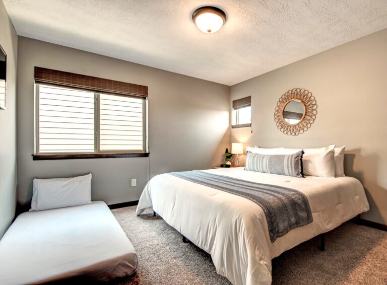 The king bedroom upstairs includes a twin floor mattress for extra sleeping space. There's also a closet with shelving and a smart TV.